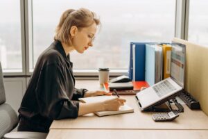 Woman writing in calendar at work. Sell Your Christmas Script blog